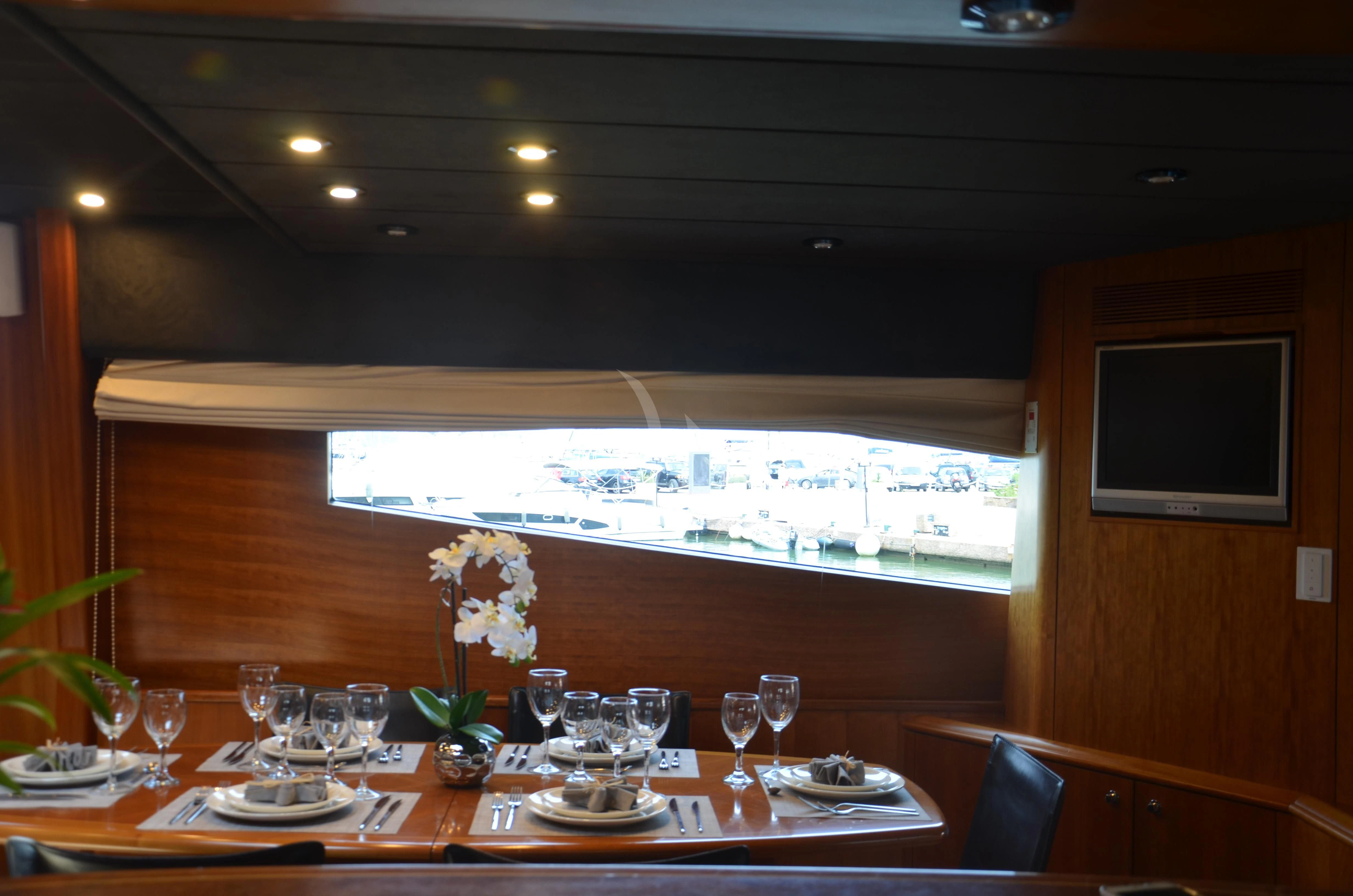 a table with wine glasses and flowers aboard FIGI Yacht for Sale