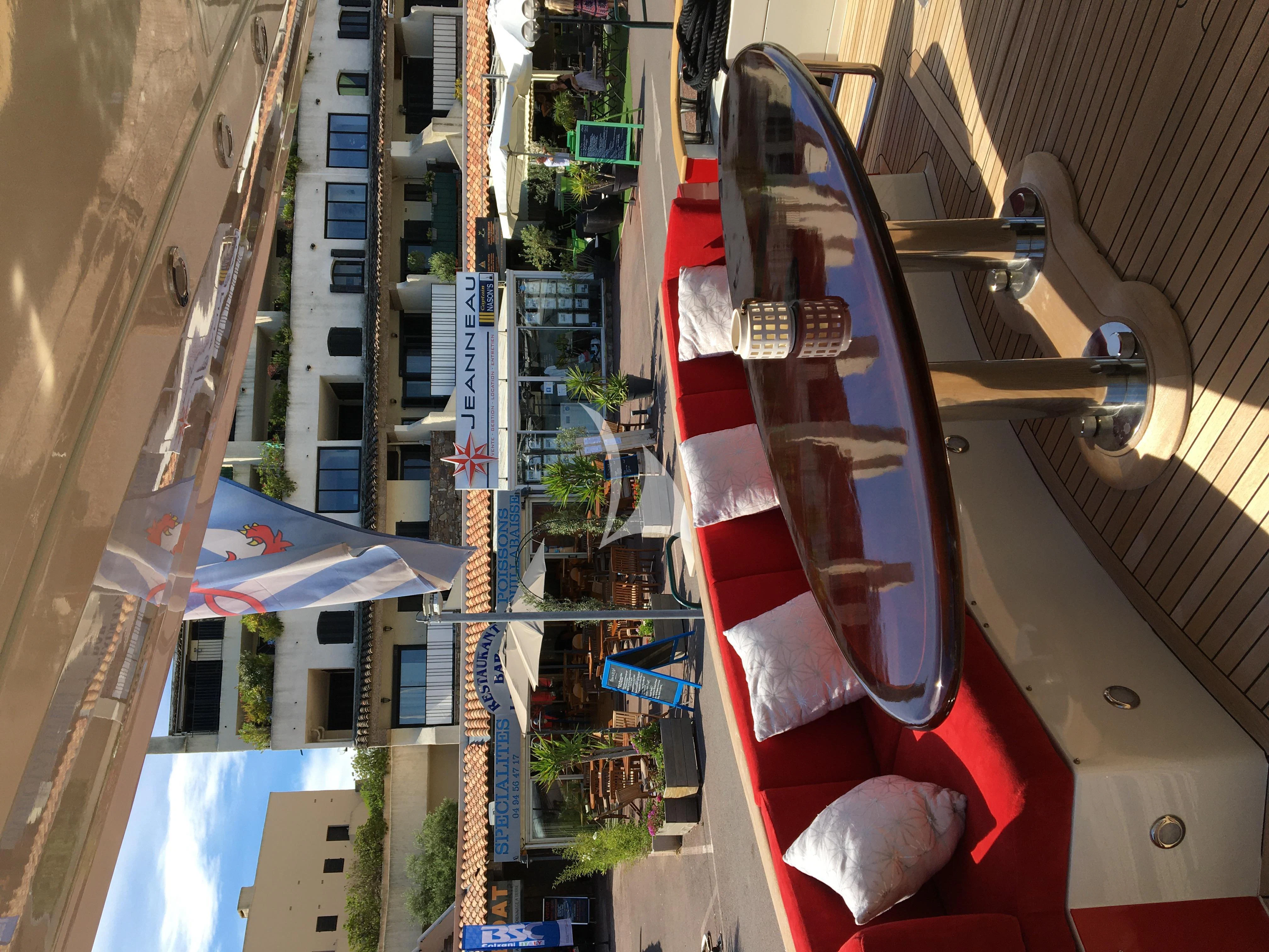 a large building with a red and white tower and a street with cars parked on the side aboard FIGI Yacht for Sale