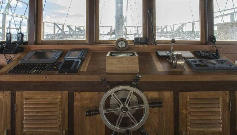 a wooden desk with a clock and other items on it aboard TIARE Yacht for Sale