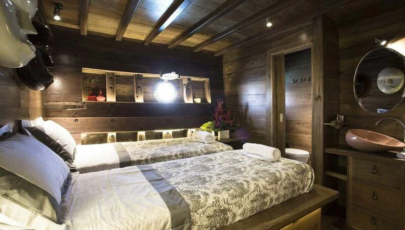 a room with a bed and a mirror aboard TIARE Yacht for Sale