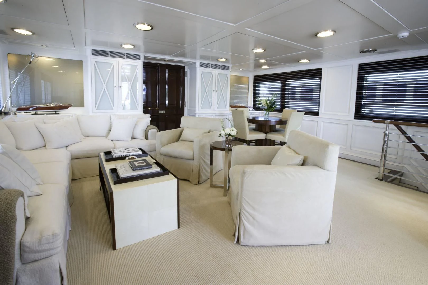 a living room with white furniture aboard EXPLORA Yacht for Sale