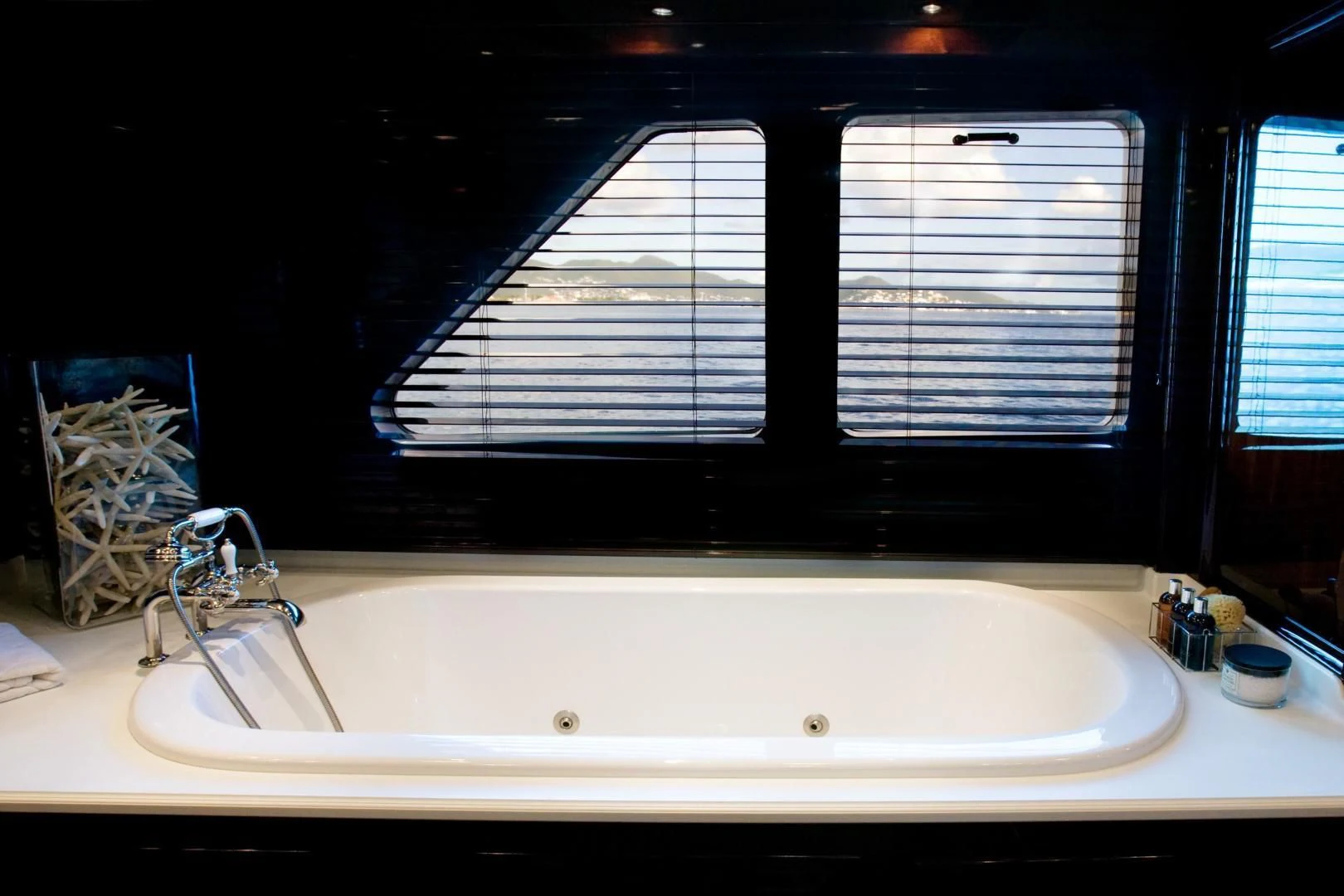 a bathtub with a window aboard EXPLORA Yacht for Sale