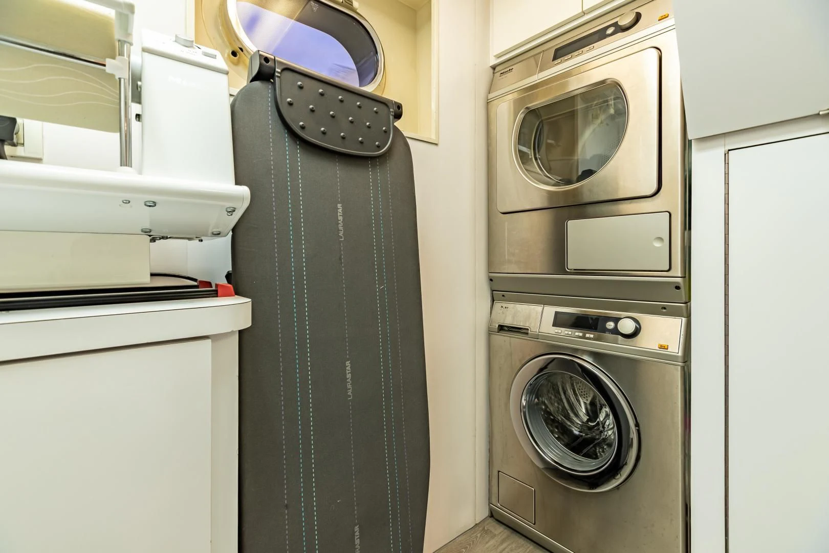 a room with a washing machine and dryer aboard EXPLORA Yacht for Sale