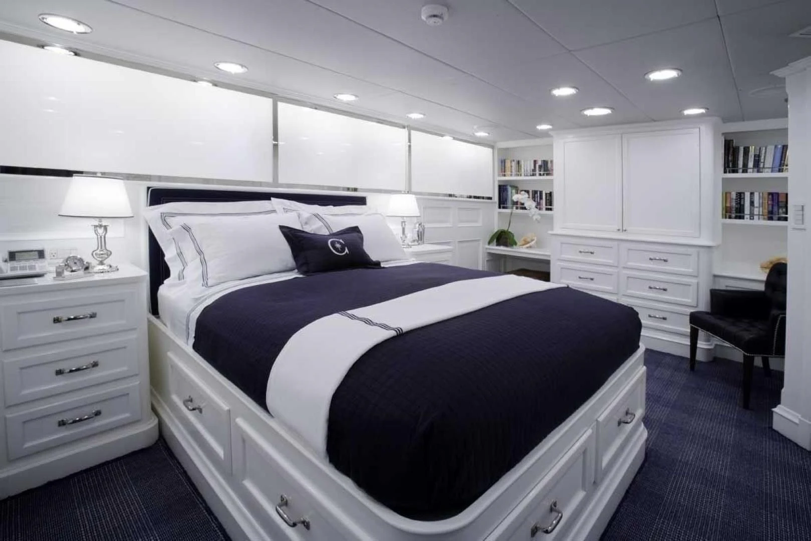 a bedroom with a bed and a desk aboard EXPLORA Yacht for Sale