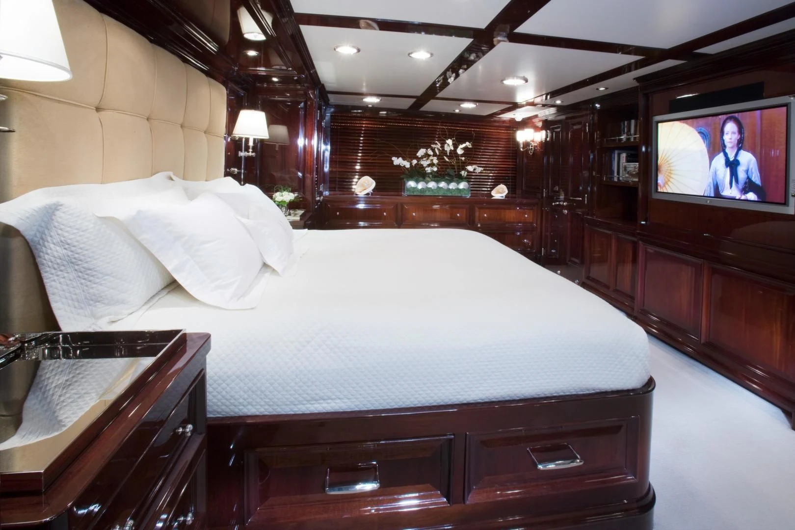 a bed with a television on the wall aboard EXPLORA Yacht for Sale