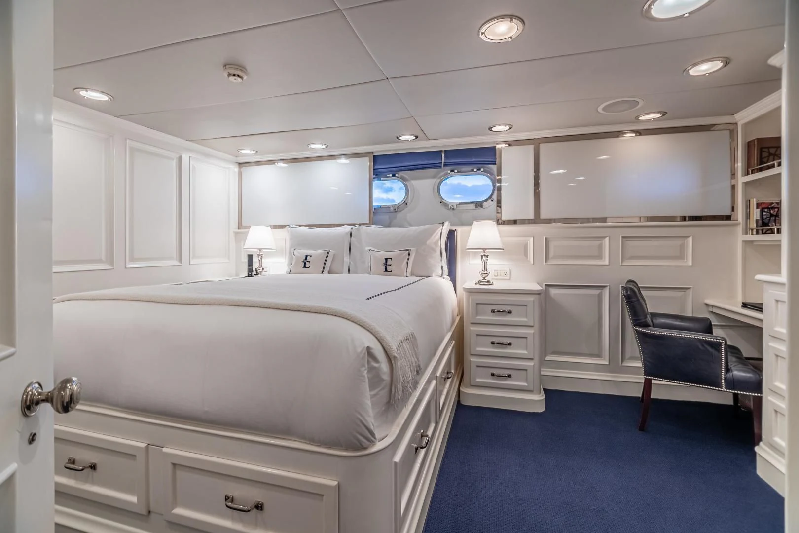 a room with a bed and a chair aboard EXPLORA Yacht for Sale