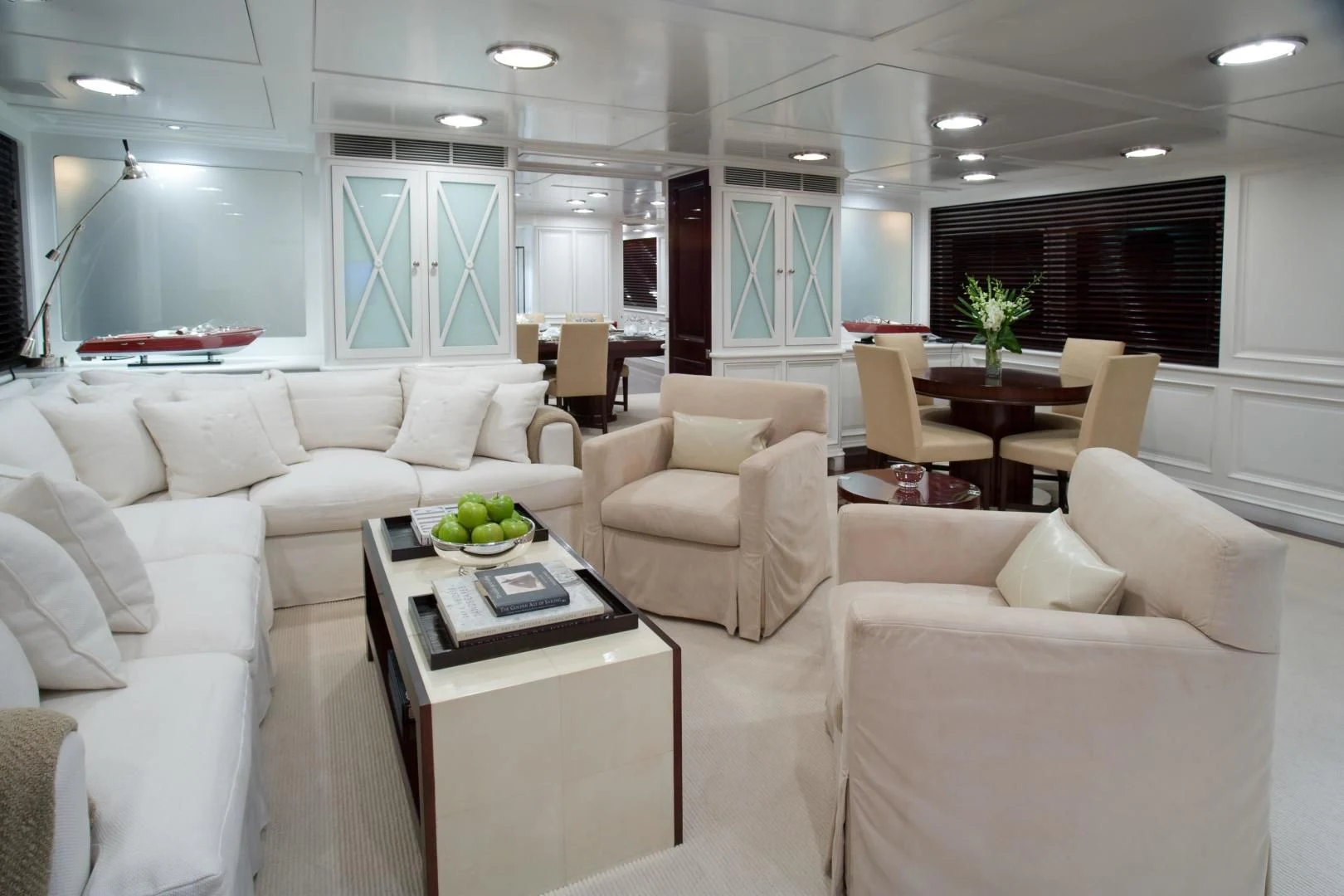 a living room with white couches aboard EXPLORA Yacht for Sale