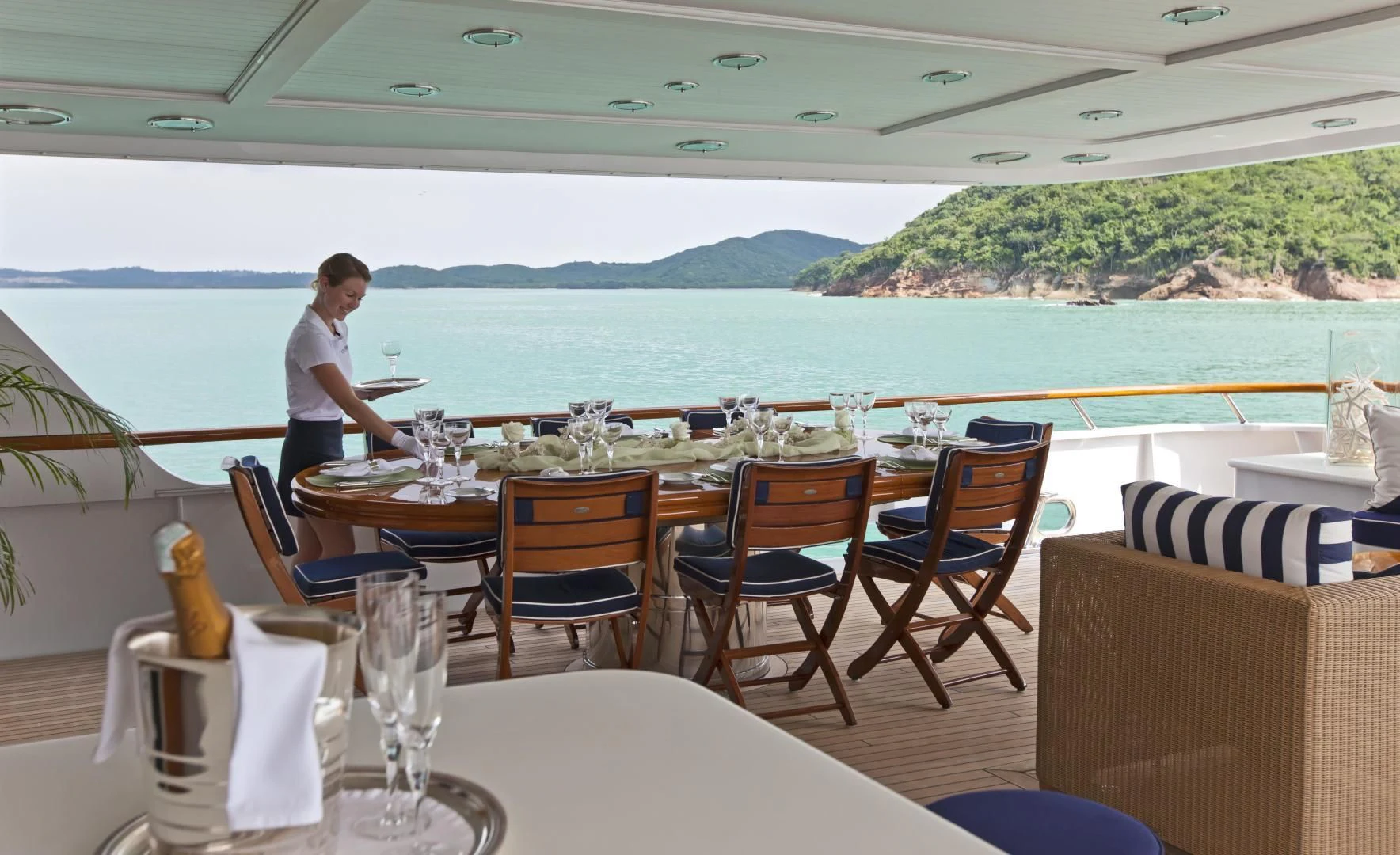a person standing on a balcony overlooking a body of water aboard EXPLORA Yacht for Sale