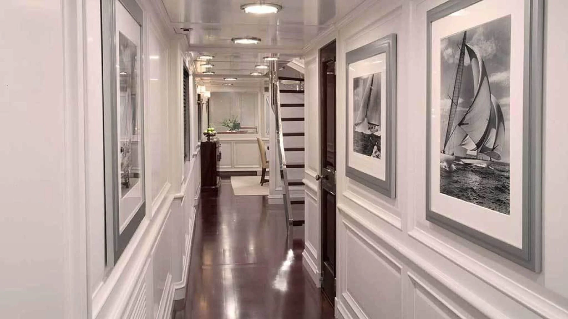 a hallway with art on the wall aboard EXPLORA Yacht for Sale