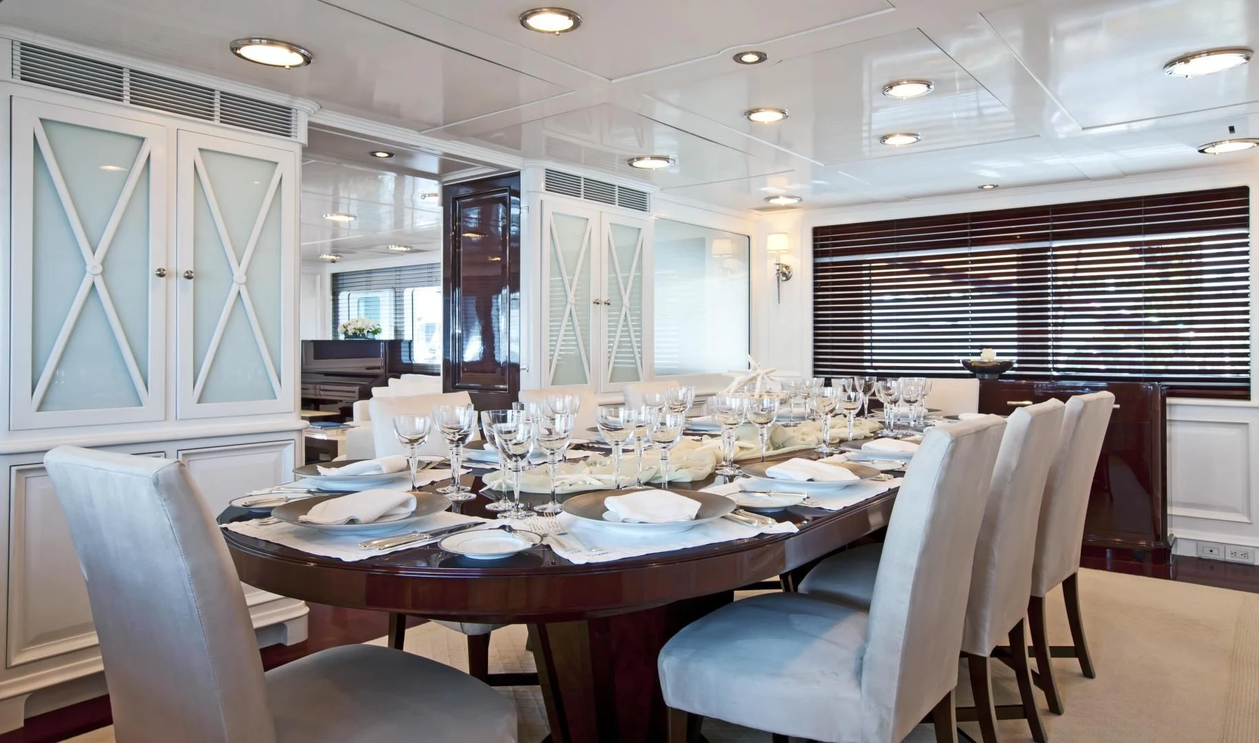 a large dining room with white chairs aboard EXPLORA Yacht for Sale