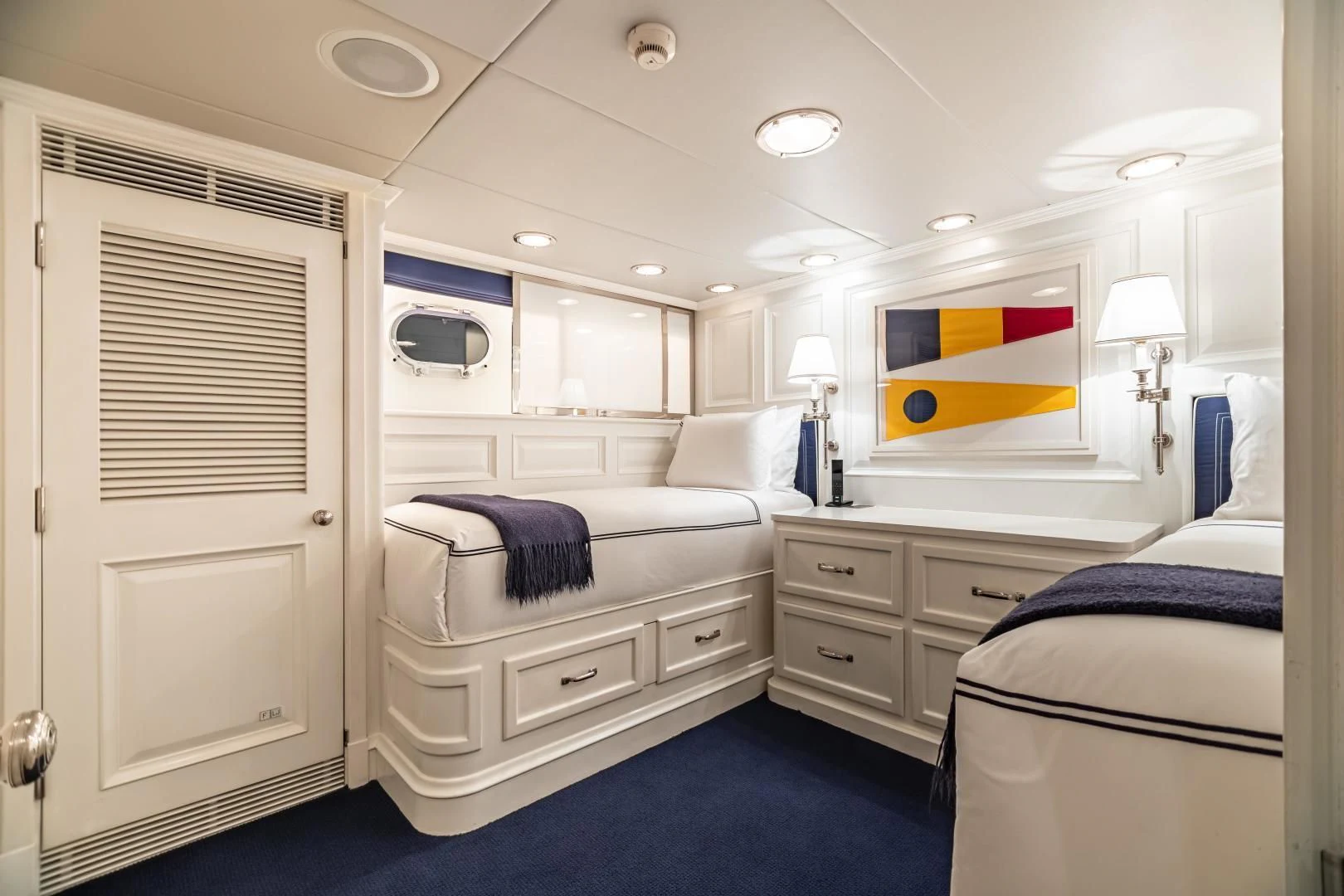 a bedroom with a bed and a desk aboard EXPLORA Yacht for Sale