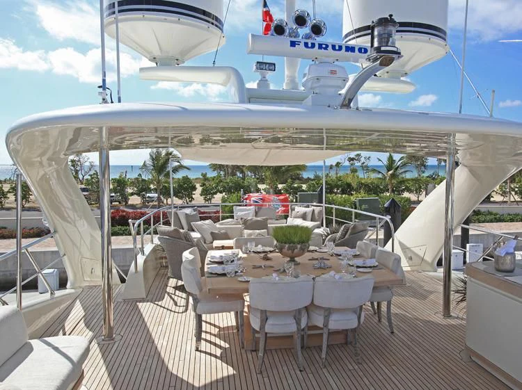 a large white tent with tables and chairs and a plane flying over it aboard SEALYON Yacht for Sale