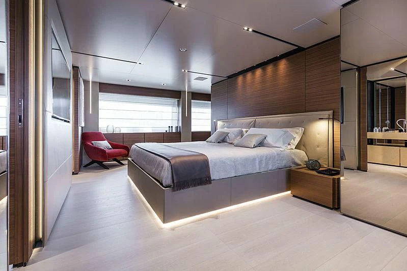 a bedroom with a bed and a chair aboard MY LARA Yacht for Sale