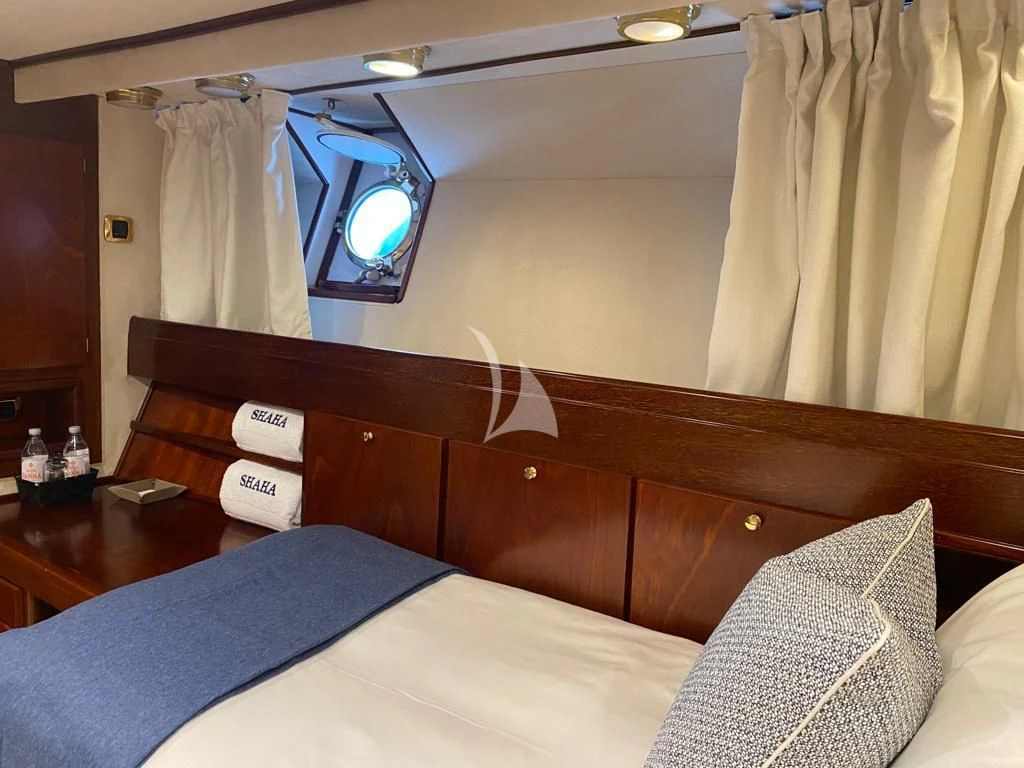 a bed with a blue blanket aboard SHAHA Yacht for Sale