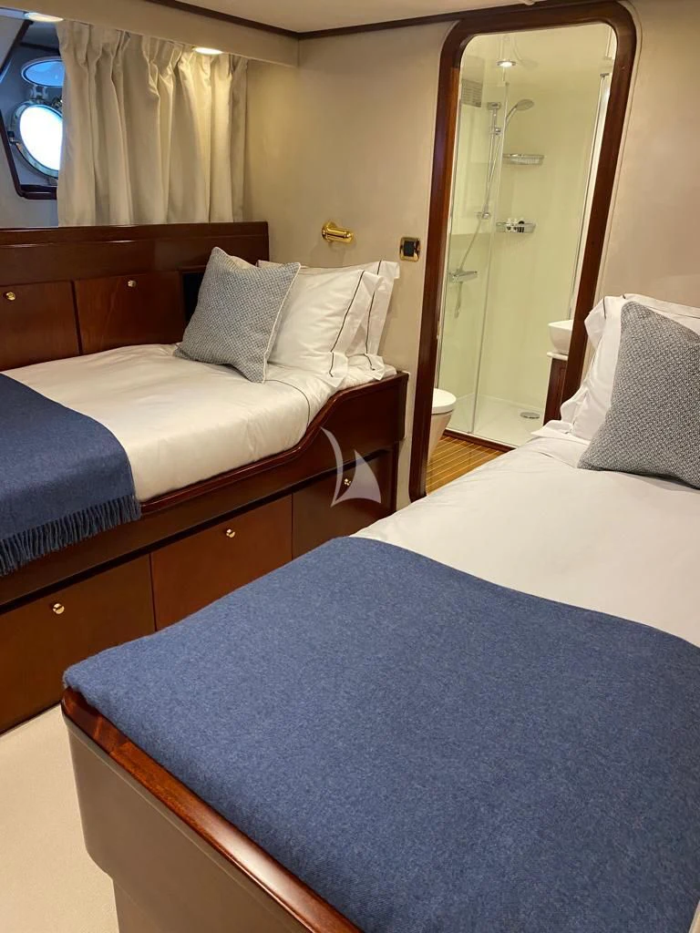 a bed with a mirror and a dresser in a room aboard SHAHA Yacht for Sale