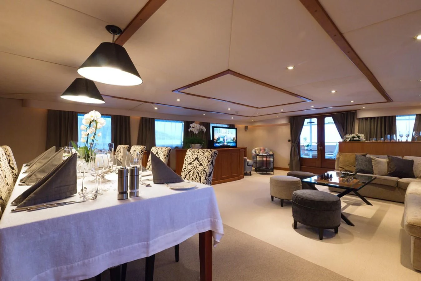 a large room with a table and chairs aboard SHAHA Yacht for Sale