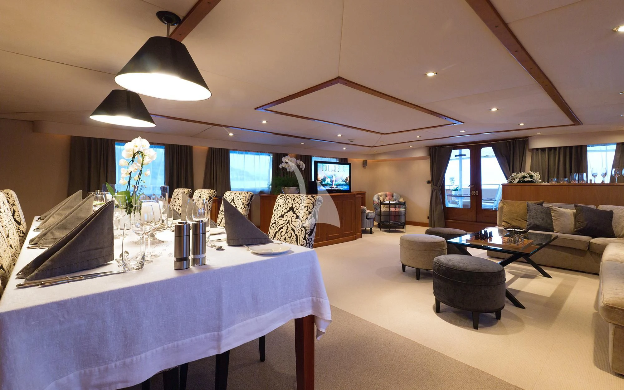 a large living room with a large table and a large window aboard SHAHA Yacht for Sale