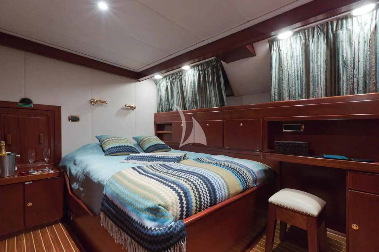 a bedroom with a bed and desk aboard SHAHA Yacht for Sale