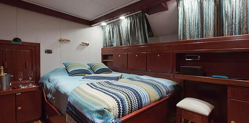 a bed with a blue and yellow blanket aboard SHAHA Yacht for Sale
