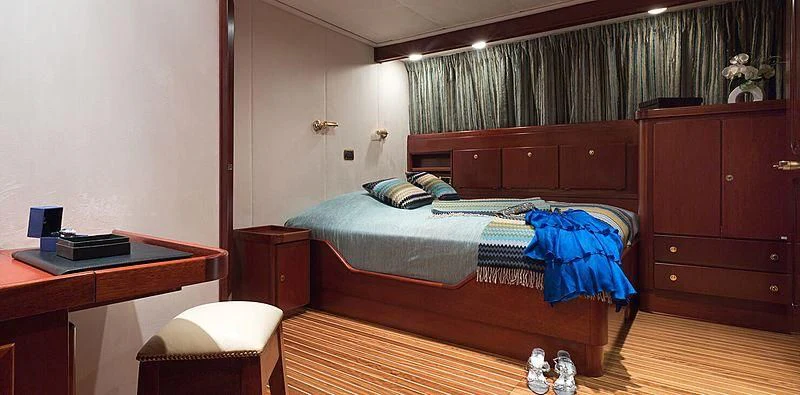 a bedroom with a bed desk and a desk aboard SHAHA Yacht for Sale