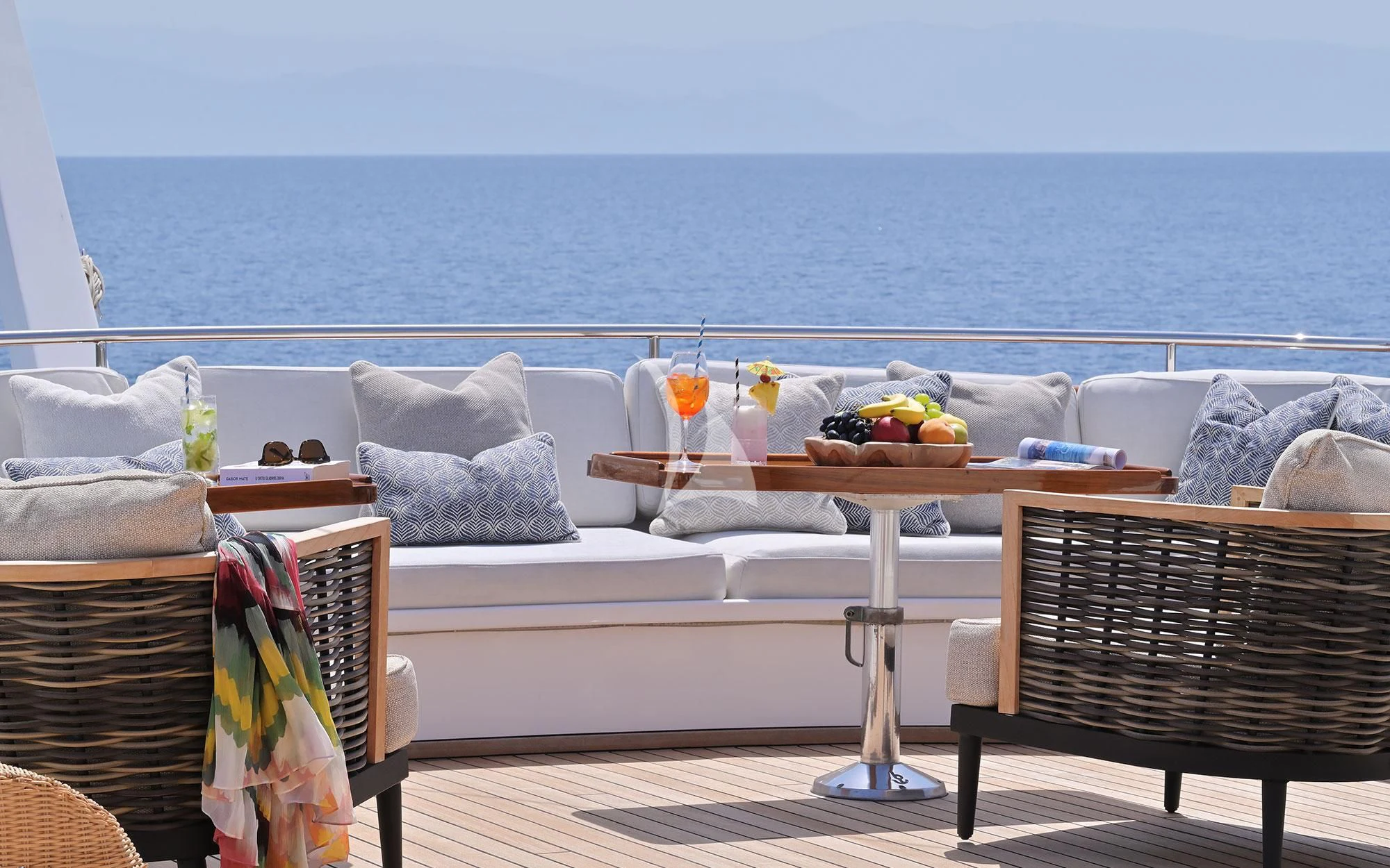 a table and chairs on a balcony overlooking the ocean aboard SHAHA Yacht for Sale