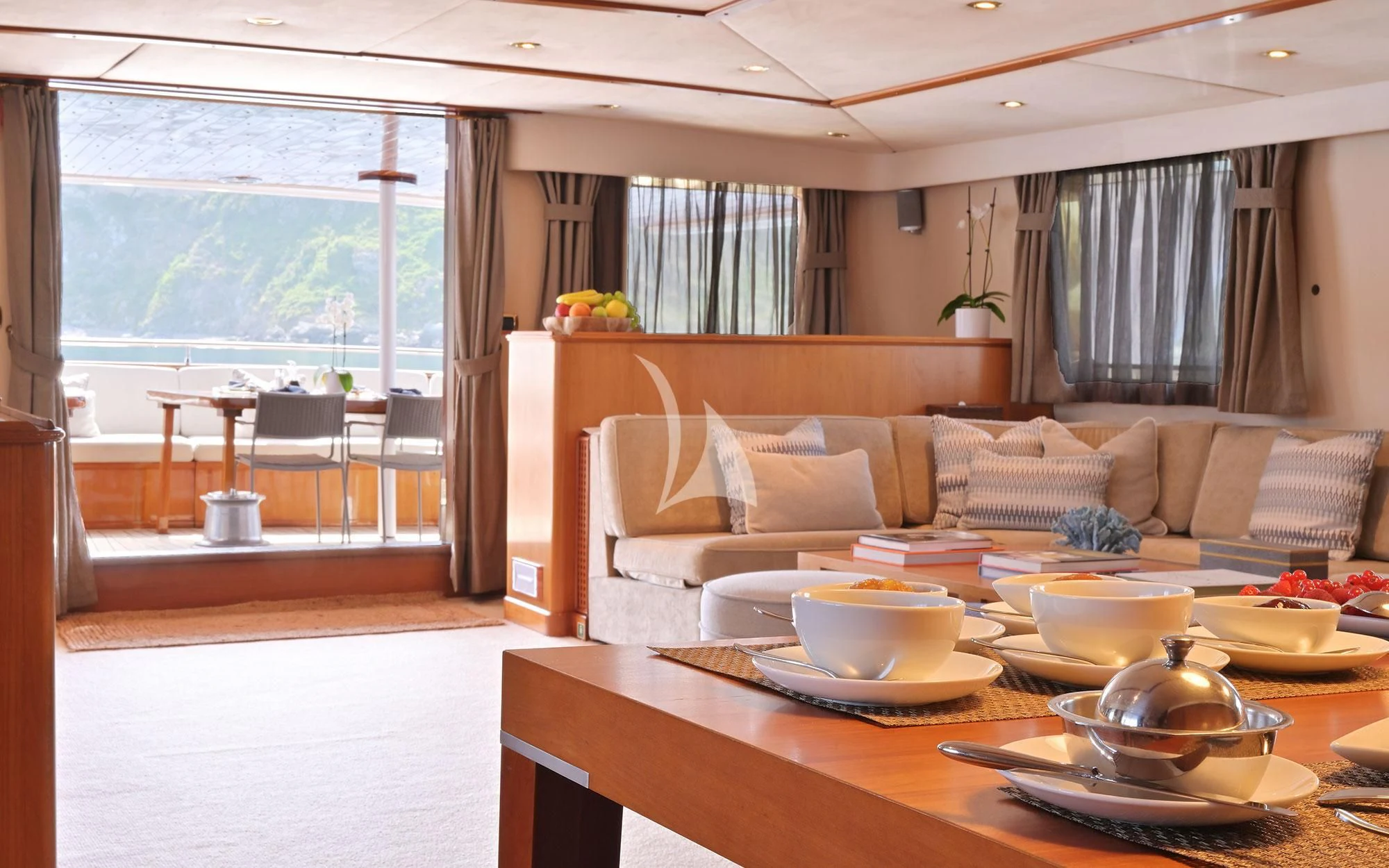 a living room with a table and couches aboard SHAHA Yacht for Sale