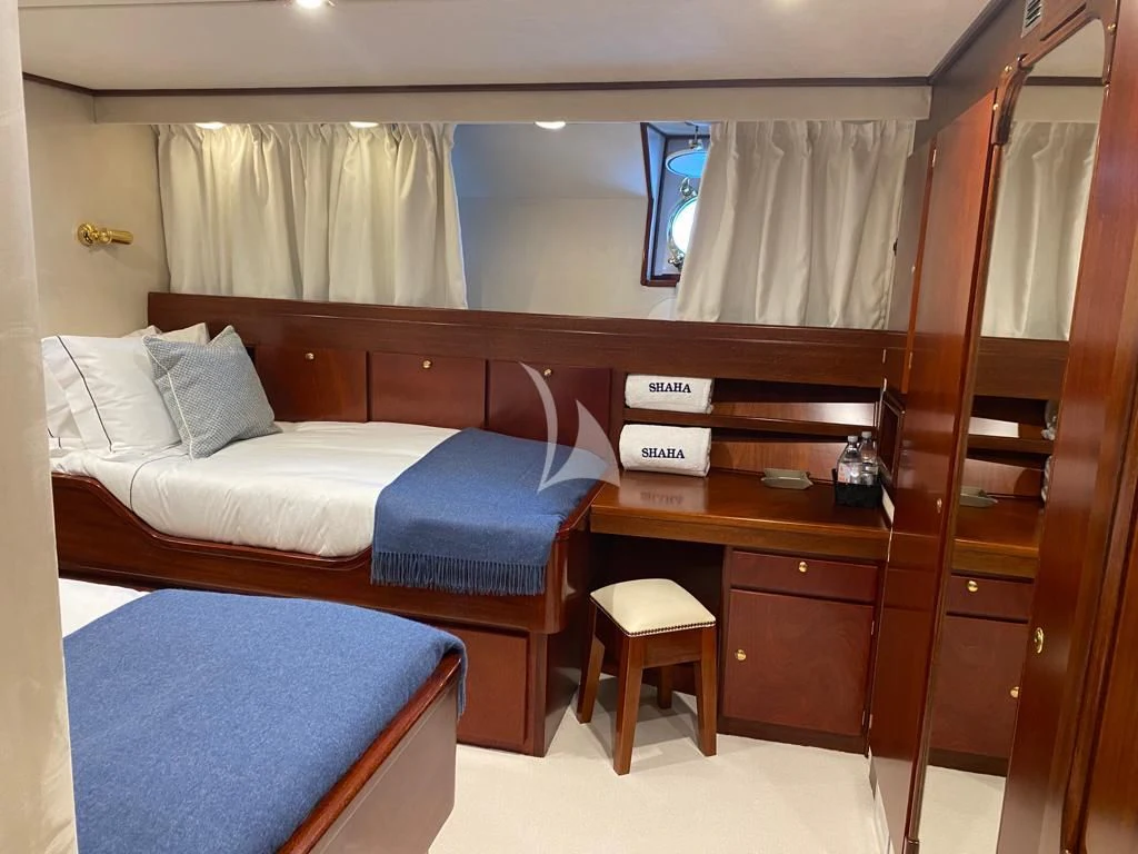 a room with a bed and desk aboard SHAHA Yacht for Sale