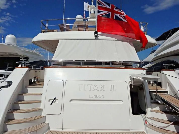 a white boat with a flag on the front aboard ARGO B Yacht for Sale