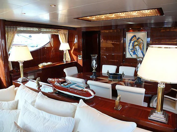 a room with a large bed and a table with chairs aboard ARGO B Yacht for Sale