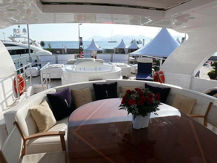 a table with chairs and a flower vase on it aboard ARGO B Yacht for Sale