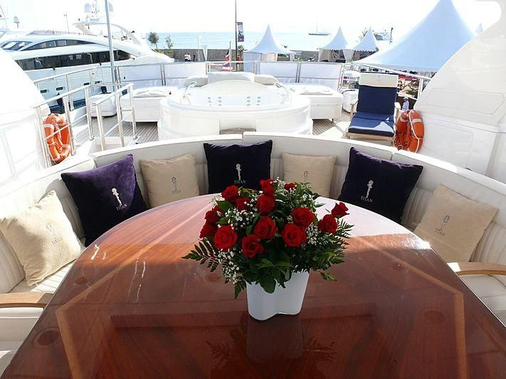 a table with chairs and a vase with flowers on it aboard ARGO B Yacht for Sale