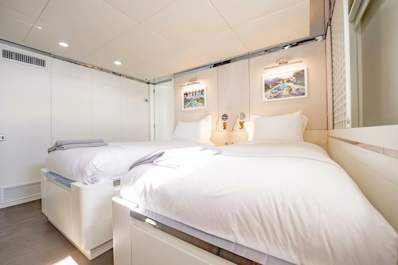 a room with white bedding aboard BG Yacht for Sale