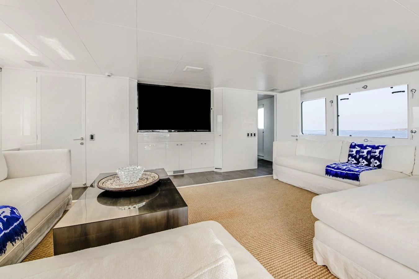 a living room with a tv and couches aboard BG Yacht for Sale