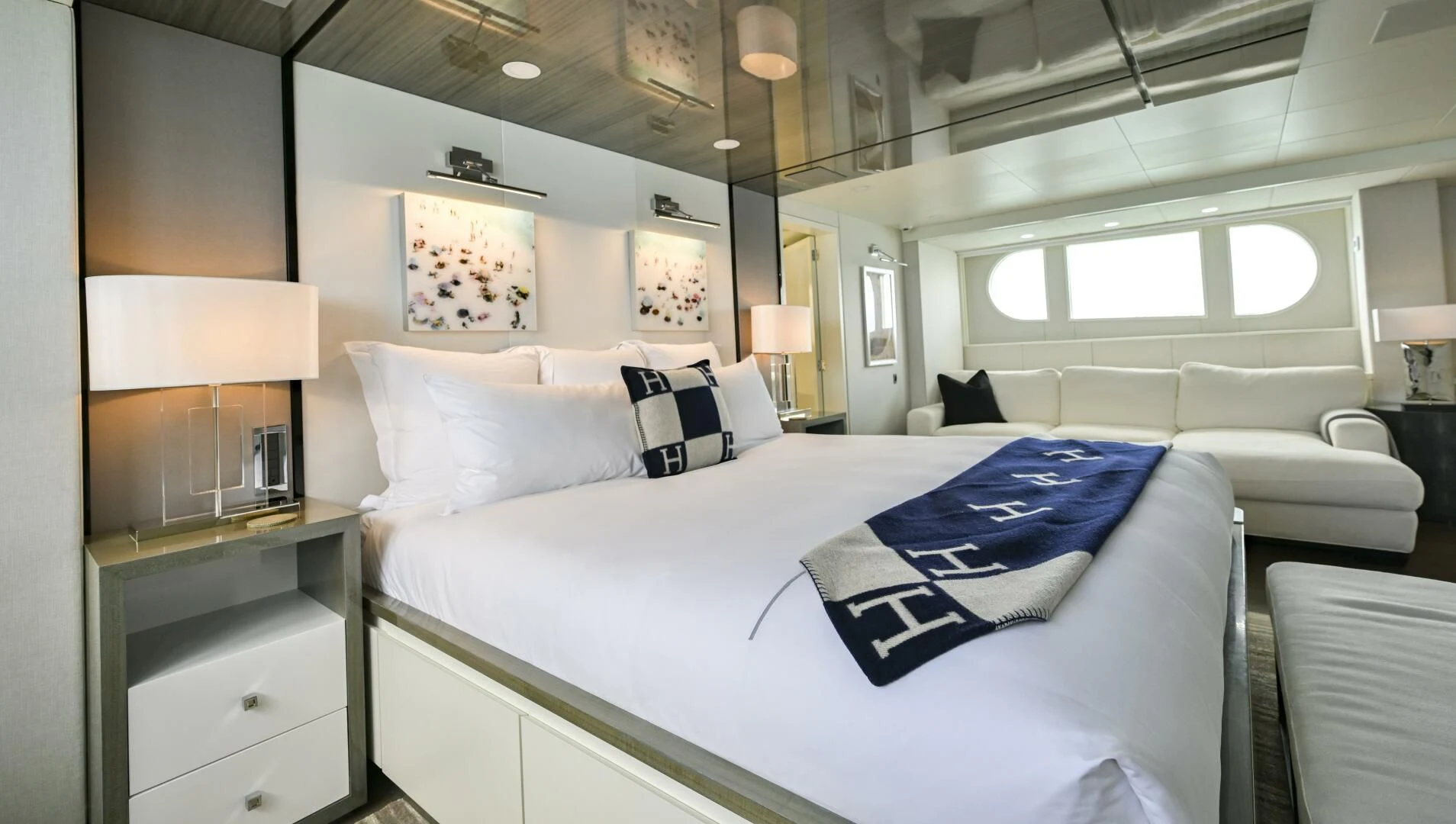a large white bed with blue sheets aboard BG Yacht for Sale