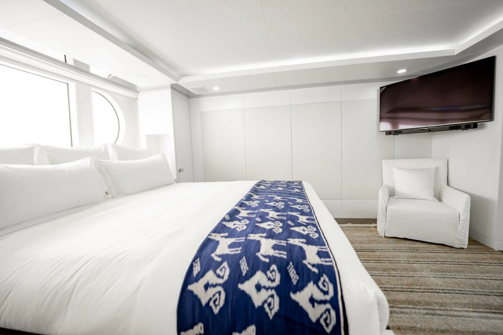 a room with a bed and a chair aboard BG Yacht for Sale