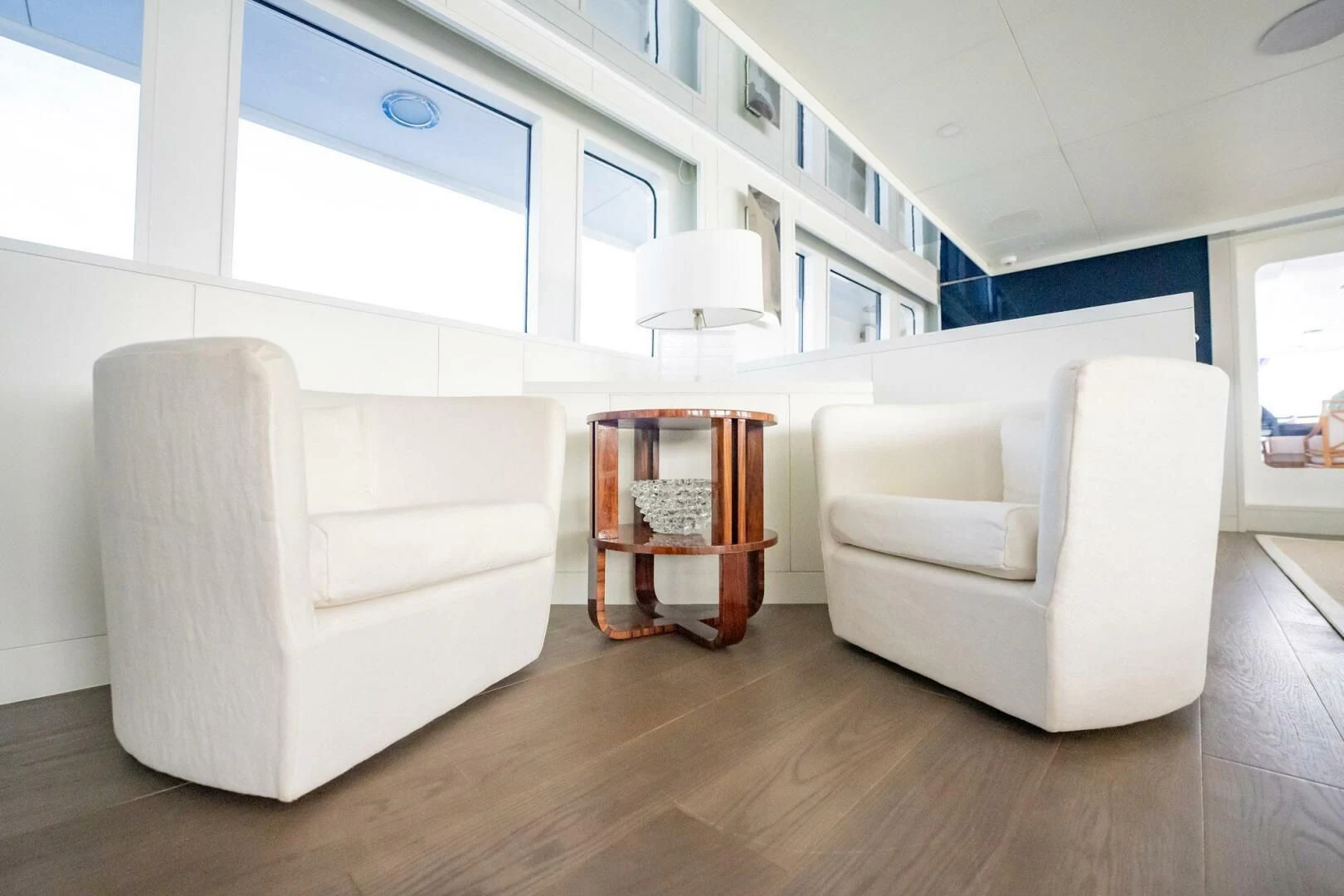 a room with a wood floor and white furniture aboard BG Yacht for Sale