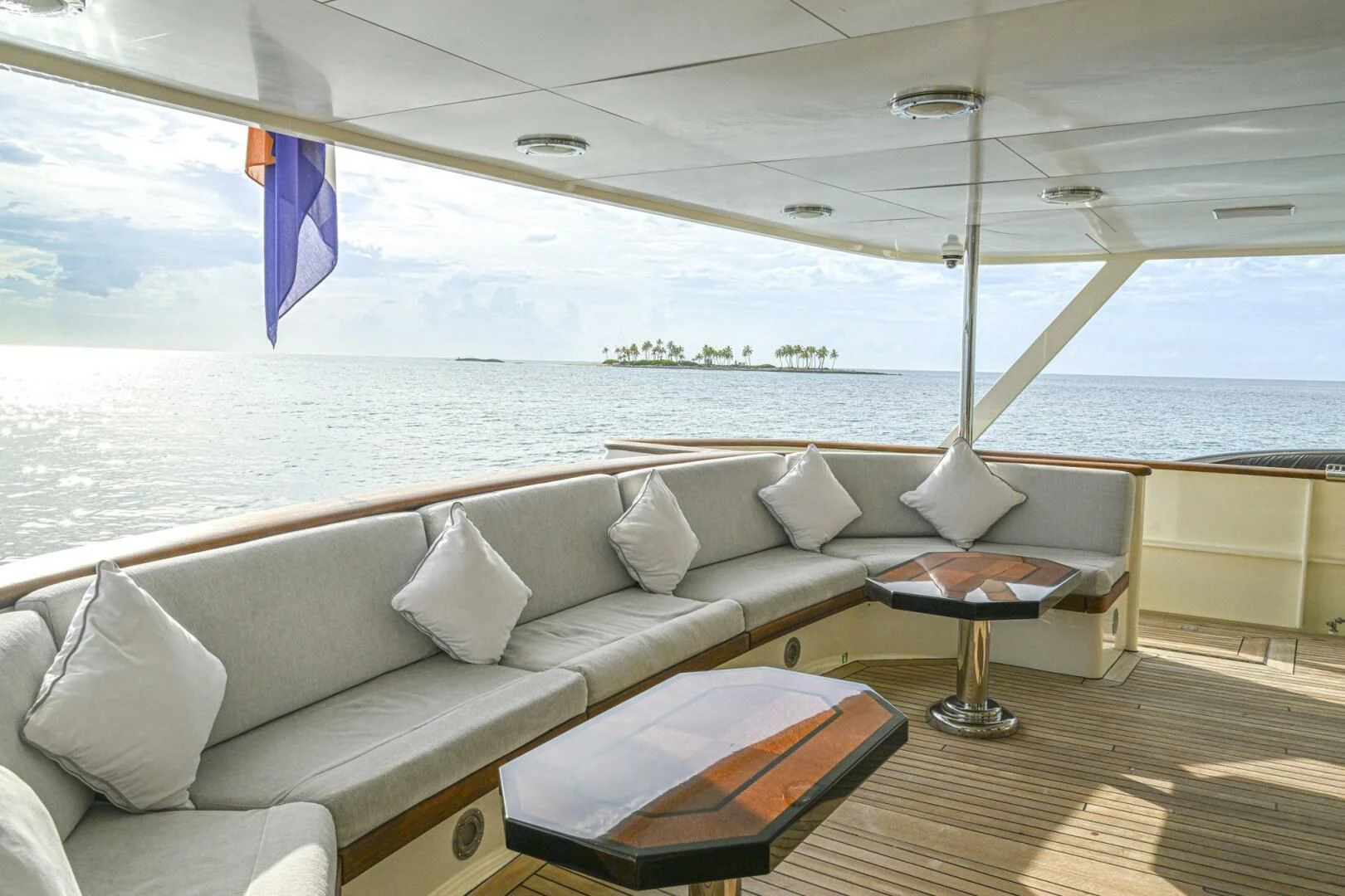 a large white sofa with pillows on a deck overlooking a body of water aboard BG Yacht for Sale