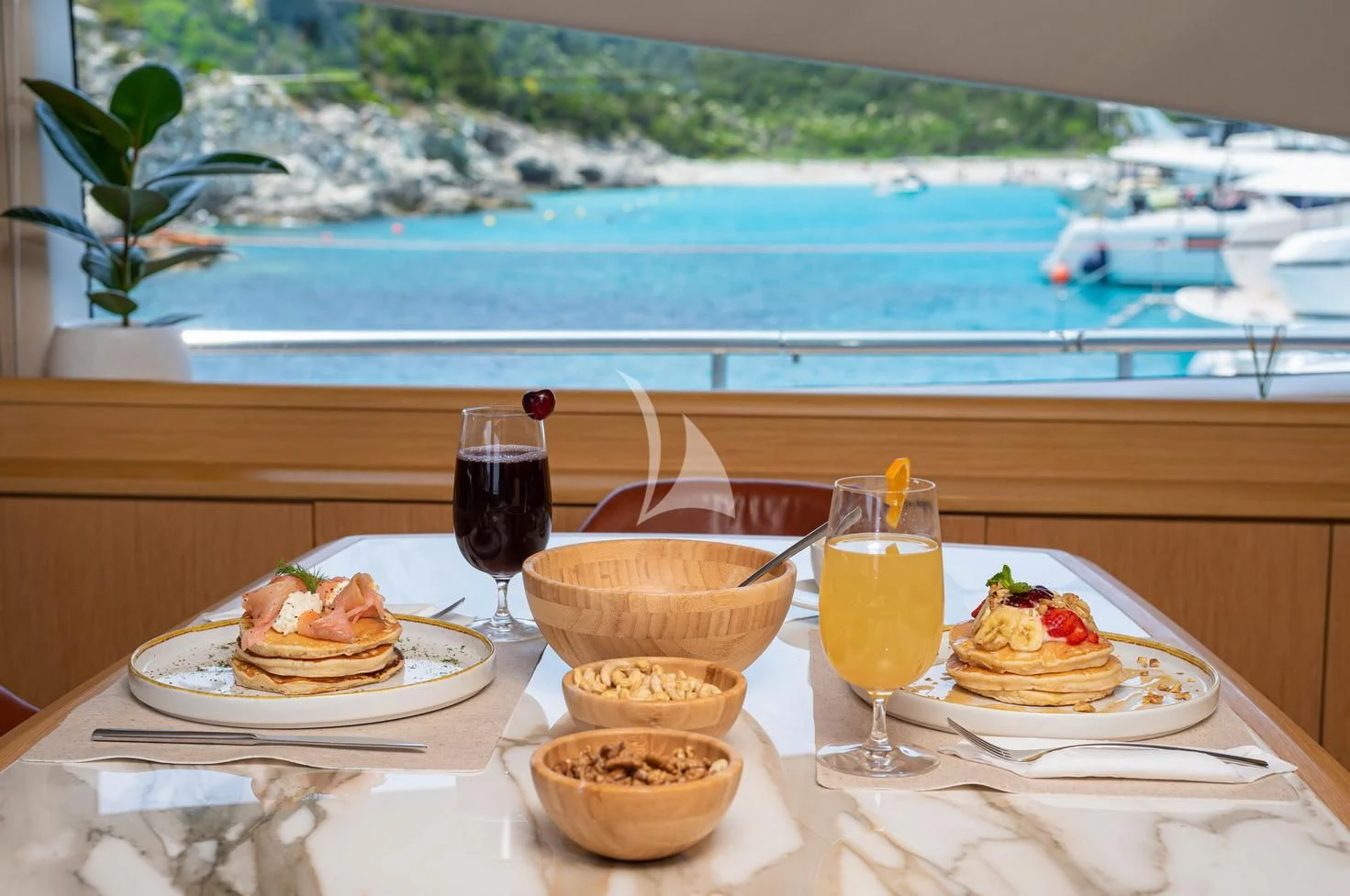 a table with food and drinks on it aboard STELA 117 Yacht for Sale
