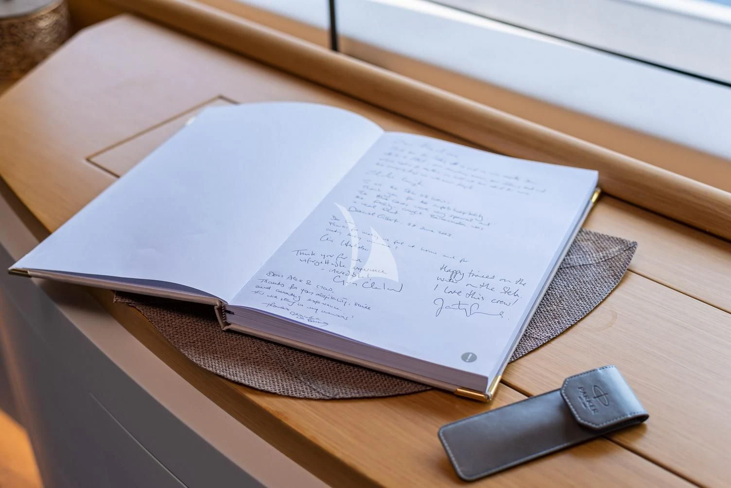 a book and a phone on a table aboard STELA 117 Yacht for Sale