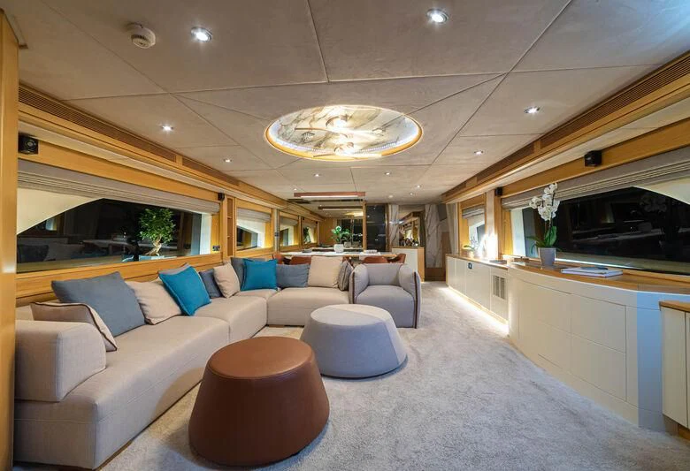 a living room with a couch and a table aboard STELA 117 Yacht for Sale