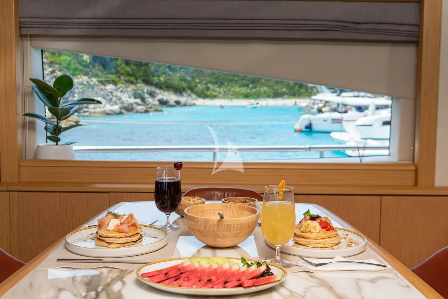 a table with food and glasses aboard STELA 117 Yacht for Sale