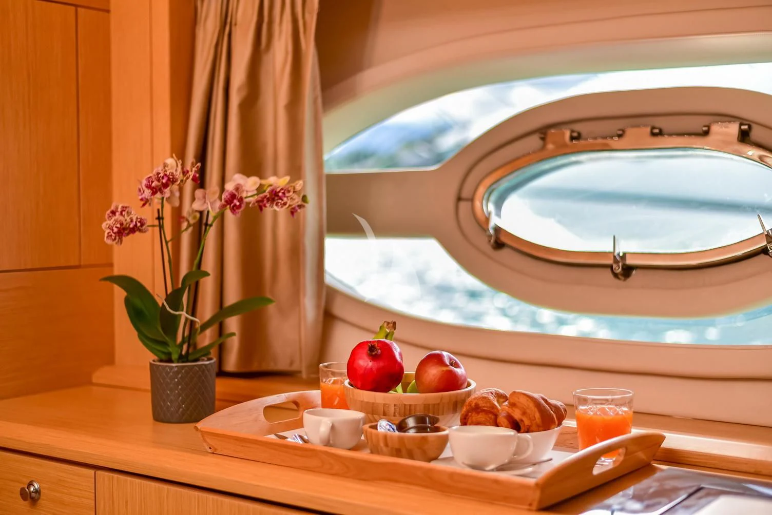 a table with food and a glass of juice aboard STELA 117 Yacht for Sale