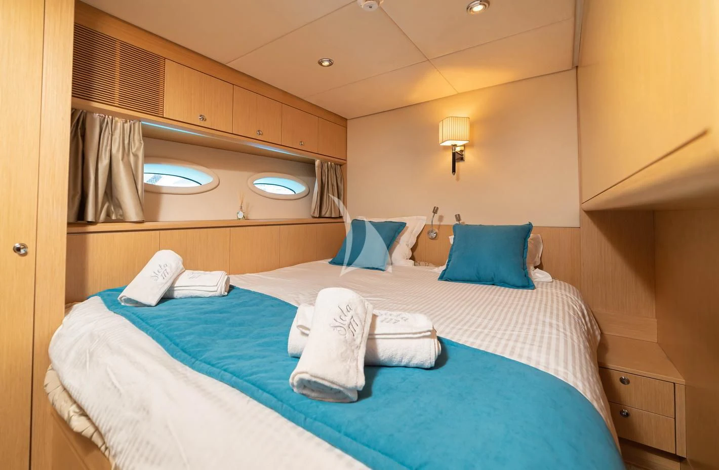 a bed with blue sheets aboard STELA 117 Yacht for Sale