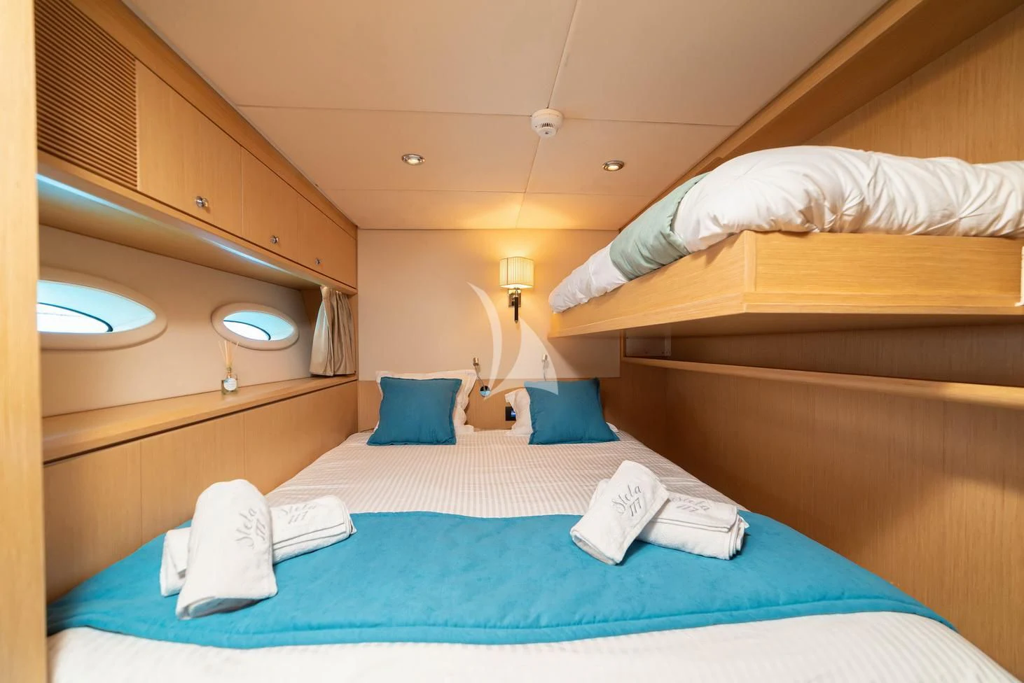 a bed with blue sheets and pillows aboard STELA 117 Yacht for Sale