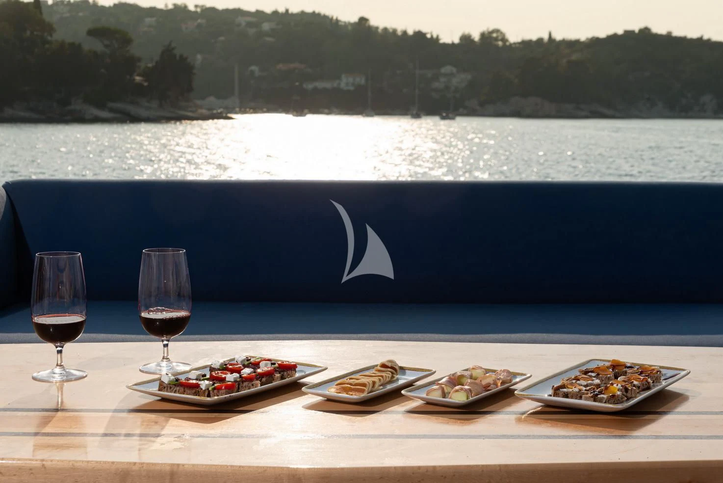 a table with food and wine aboard STELA 117 Yacht for Sale
