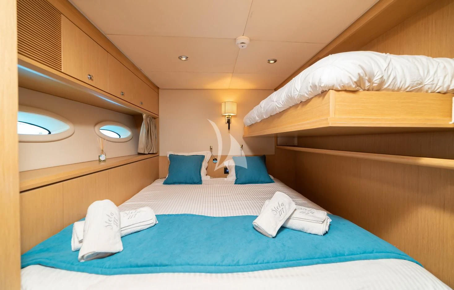 a bed with blue sheets aboard STELA 117 Yacht for Sale