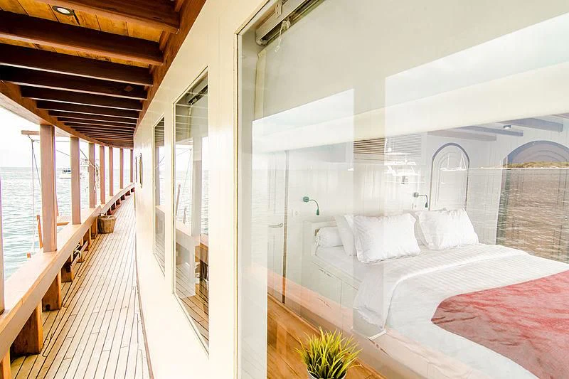 a room with a bed and a balcony aboard MISCHIEF Yacht for Sale