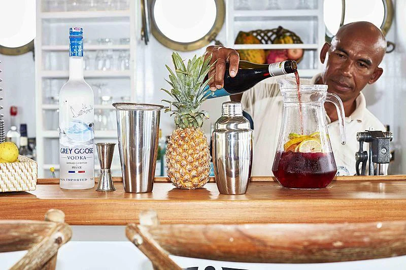 a person pouring a drink into a glass aboard MISCHIEF Yacht for Sale