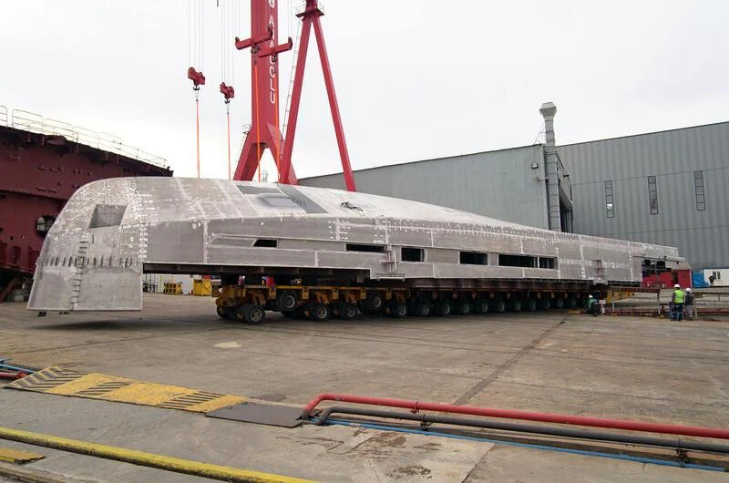 a large grey building with a red crane on top aboard AISHA Yacht for Sale
