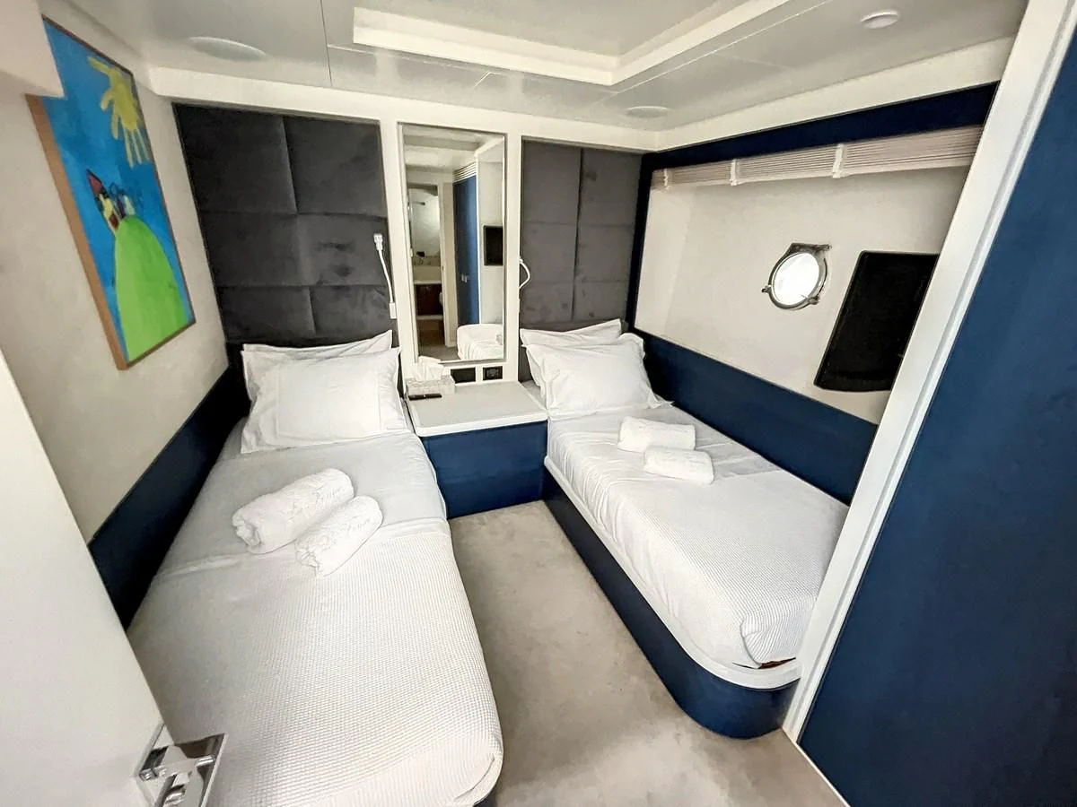 a room with beds and a window aboard LA FENICE Yacht for Charter